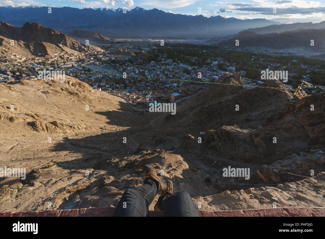 Reisen Stadt, in Leh in Ladakh, Indien. ein Mann sitzt auf einer Klippe mit Blick auf die Stadt leh am Morgen Stockfoto