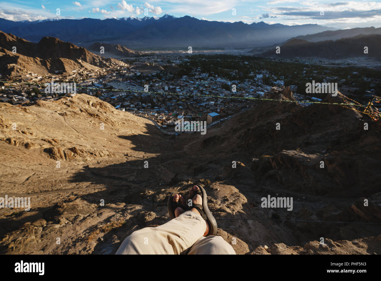 Reisen Stadt, in Leh in Ladakh, Indien. ein Mann sitzt auf einer Klippe mit Blick auf die Stadt leh am Morgen Stockfoto
