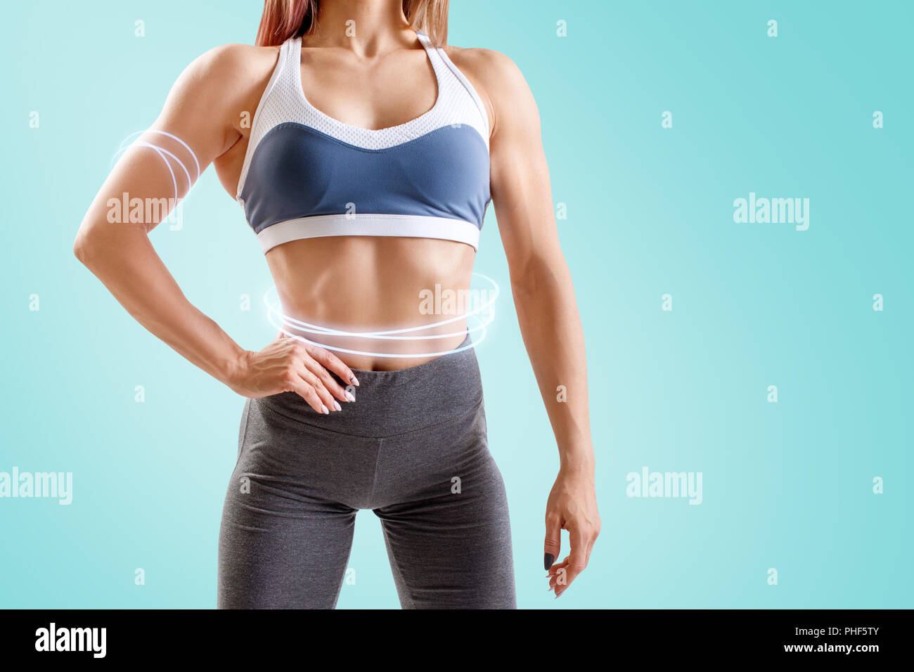Junge Frau in Sportkleidung demonstriert ihre Muskulatur athletischer Körper. Stockfoto