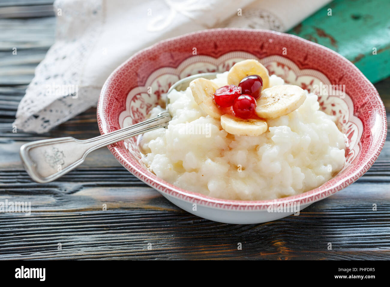 Reisbrei mit Bananen, Beeren und Honig. Stockfoto