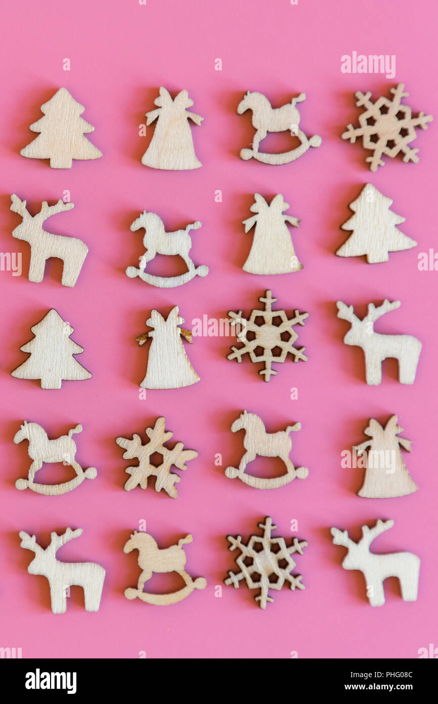 Weihnachten rosa Hintergrund. Holz- Weihnachten figuren von einem  Weihnachtsbaum, eine Glocke, ein Reh und Schneeflocken auf einem rosa  Hintergrund. vertikale Foto Stockfotografie - Alamy