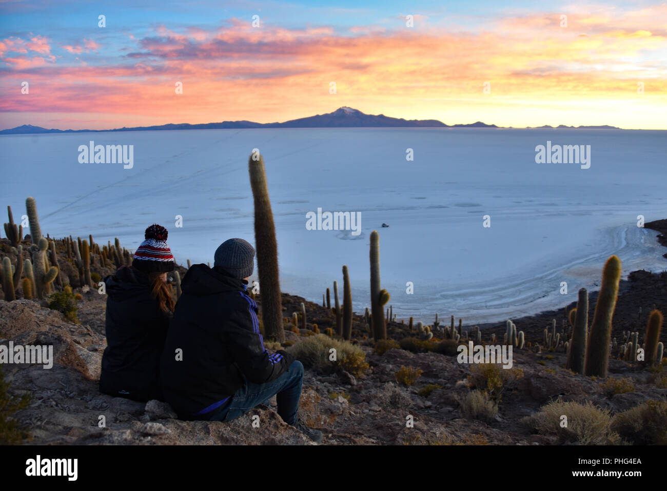 Ein paar genießen Sie den Sonnenaufgang mit Blick auf den Salar de Uyuni von Isla Incahuasi. Uyuni, Bolivien Stockfoto