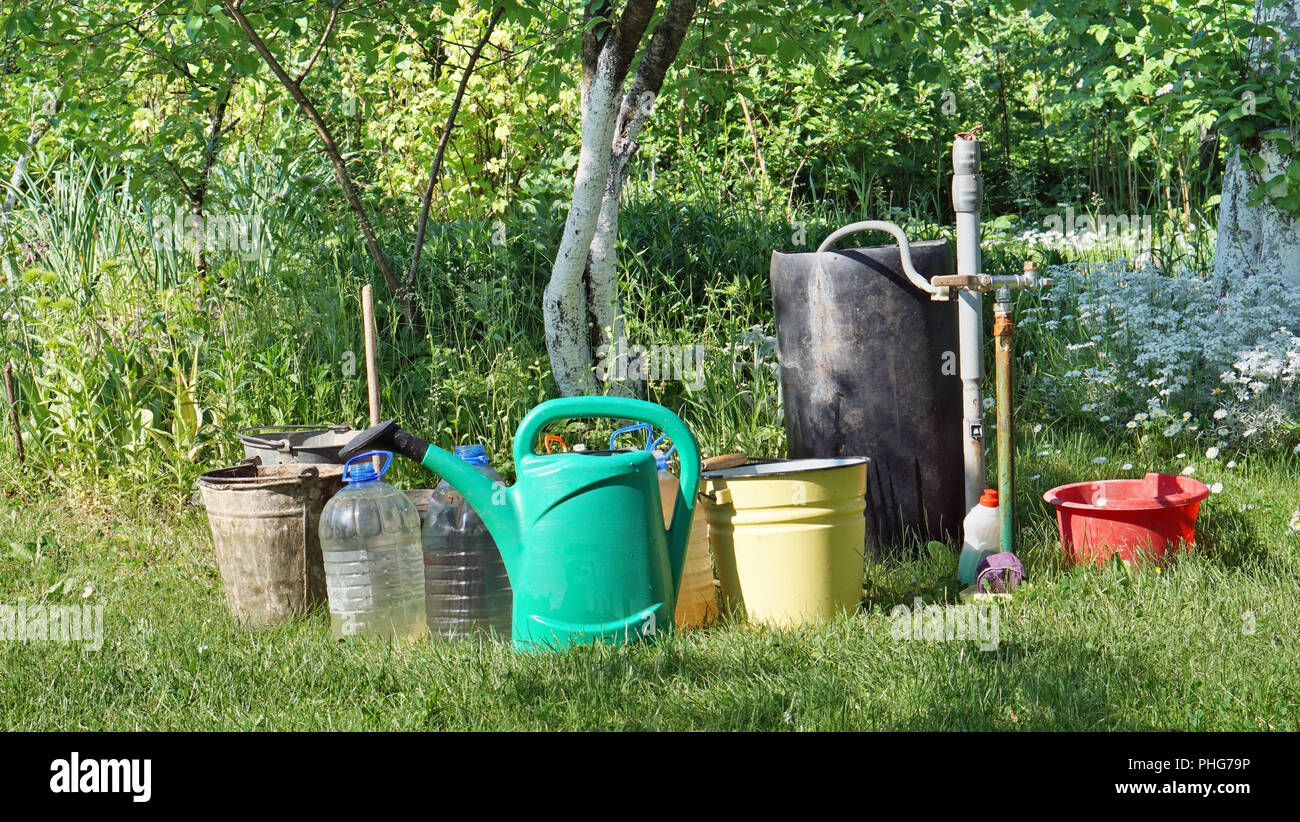 Eimer und Kanister mit Wasser im Garten Stockfoto