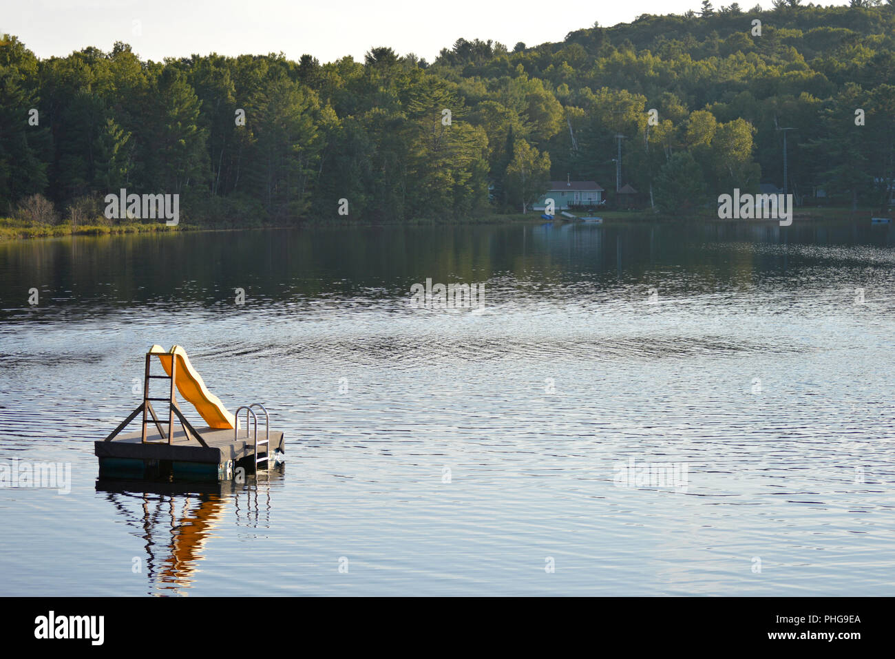 Ein Schwimmdock mit einer Spaß gelbe Folie auf einem See in Western Quebec, Kanada. Stockfoto