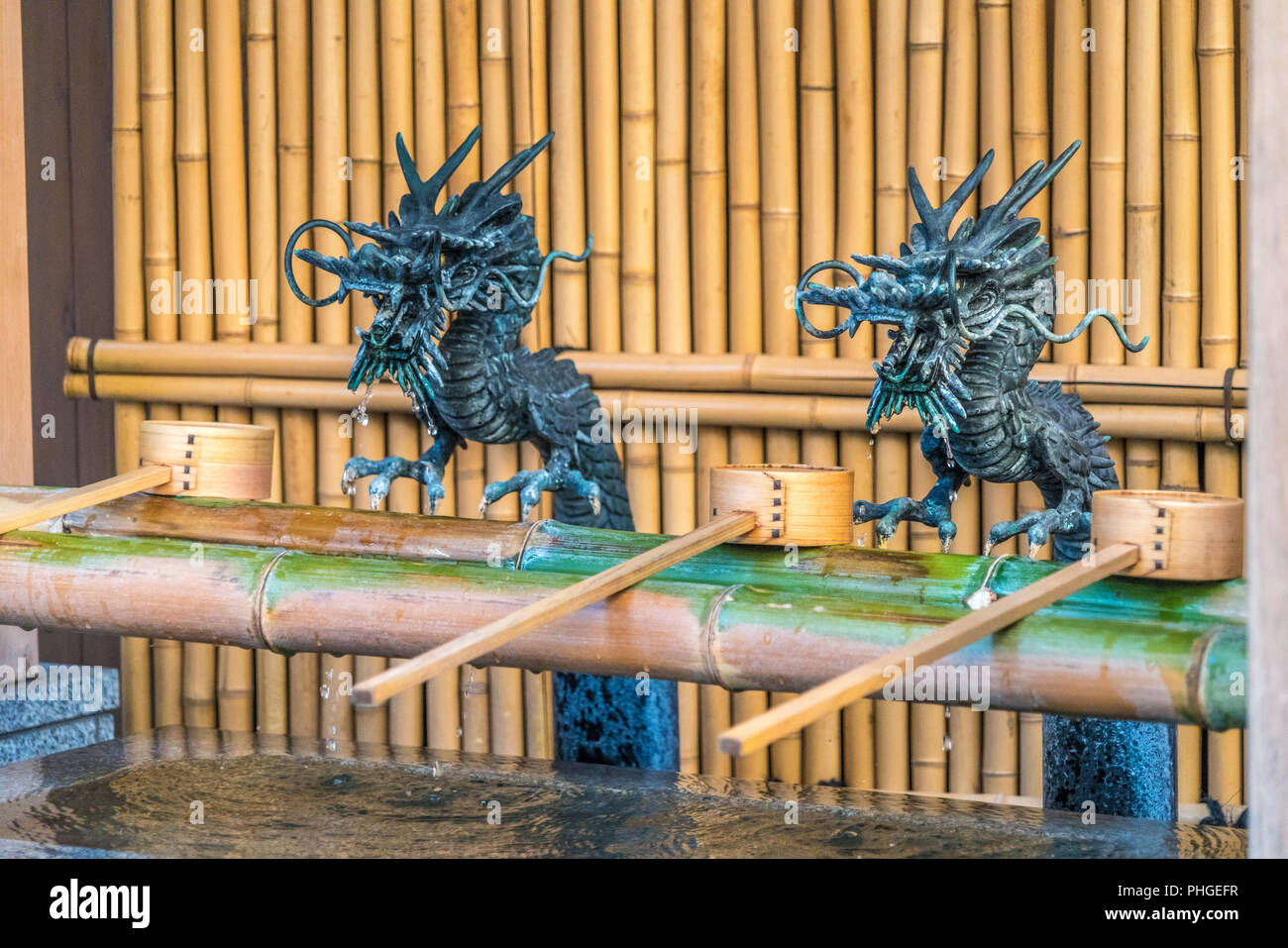Drachen und hisaku Chozuya dipers am Wasser Waschung Pavillon der Koami Schrein oder Daimyojin Koami Inari. Shinto Schrein zu Benzaiten Gottheit gewidmet Stockfoto