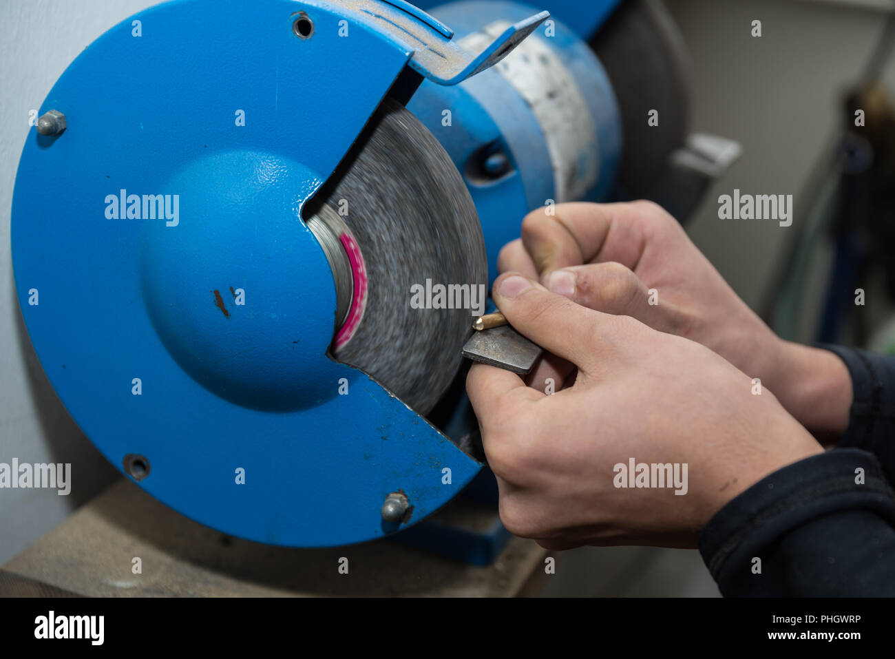 Facharbeiter schleift Metallstück mit einem Schleifer - close-up Stockfoto