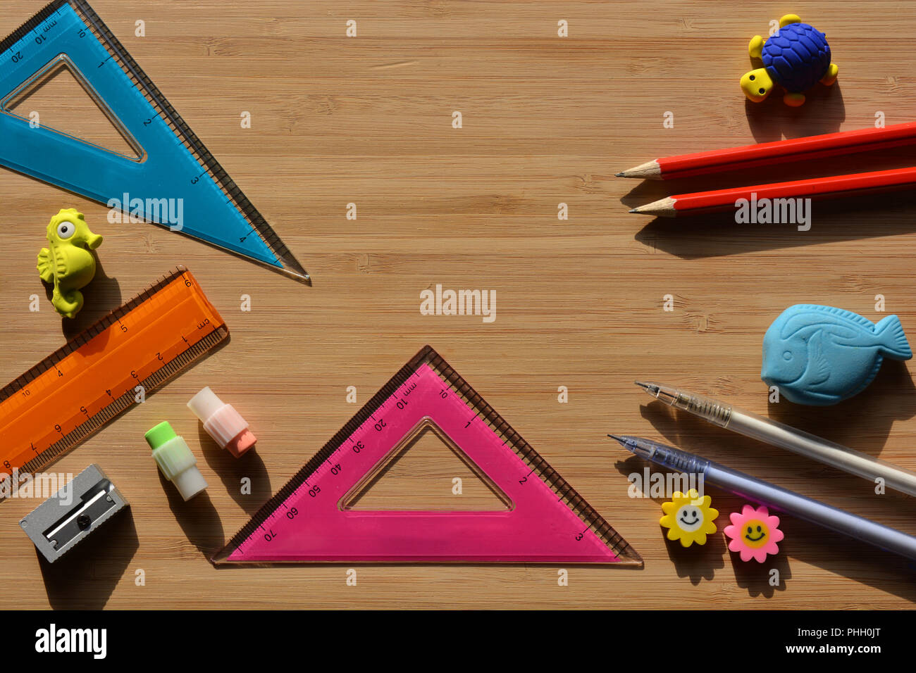 Bleistifte, Radiergummis, Spitzer, Lineal und geodreieck auf einer hölzernen Desktop mit Kopieren, zurück zu Schule Mathematik Essentials. Flatlay Fotografie Stockfoto