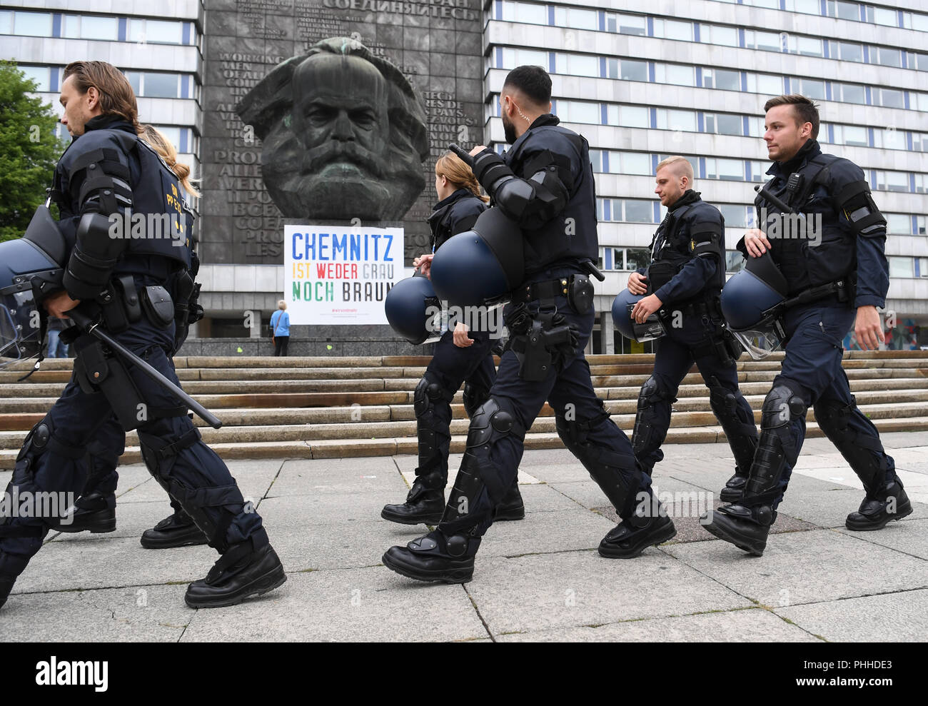 Chemnitz, Deutschland. 01 Sep, 2018. 01.09.2018, Sachsen, Chemnitz: Polizei marschieren hinter der Karl-Marx-Monument. Foto: Ralf Hirschberger/dpa/Alamy leben Nachrichten Stockfoto