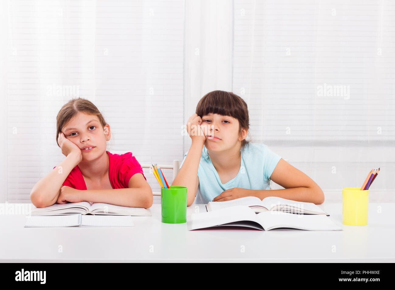 Trauriges kleines Mädchen müssen zu Hause bleiben und ihre Hausaufgaben machen, aber sie würde lieber draußen spielen. Stockfoto