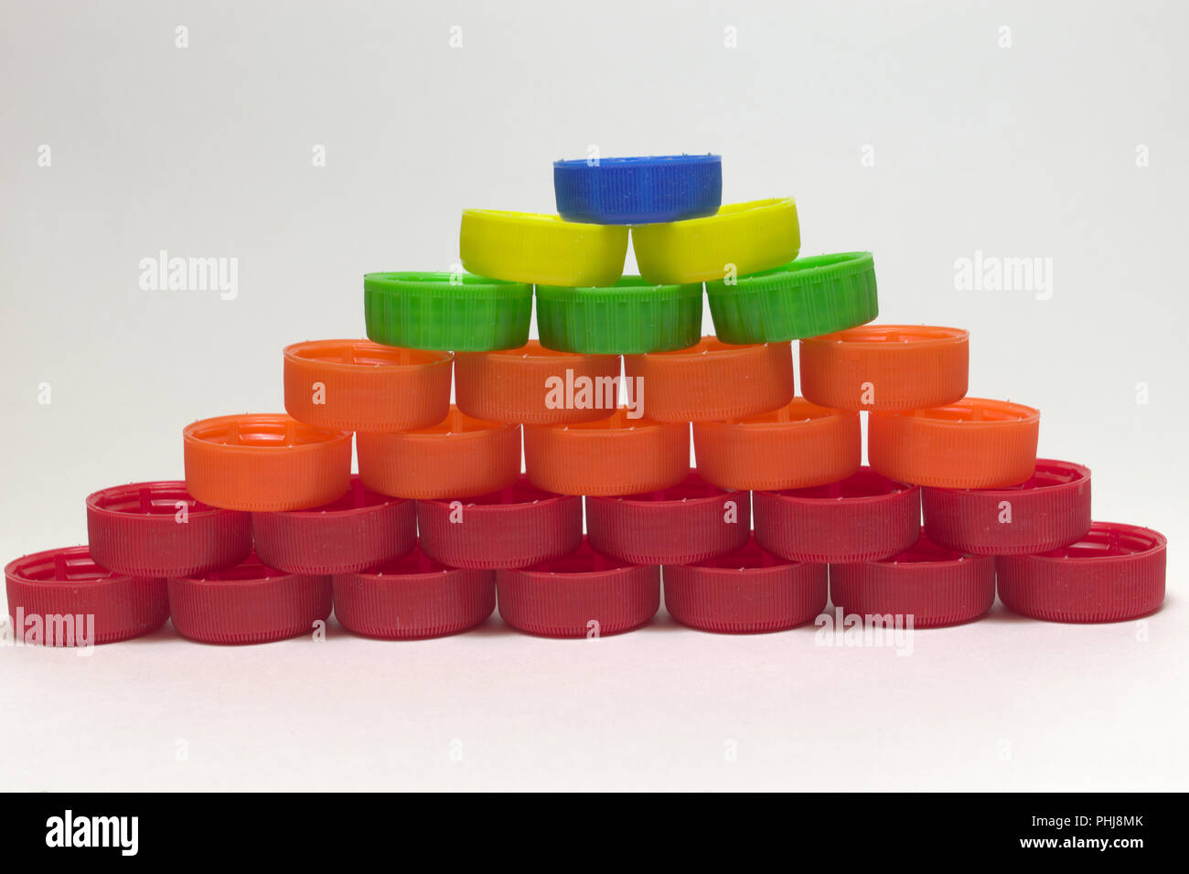 Ordentlich Pyramide aus Kunststoff Flaschenverschlüsse, nicht groß, in Schichten von Farbe gefaltet. Wiederverwendung und Recycling Stockfoto