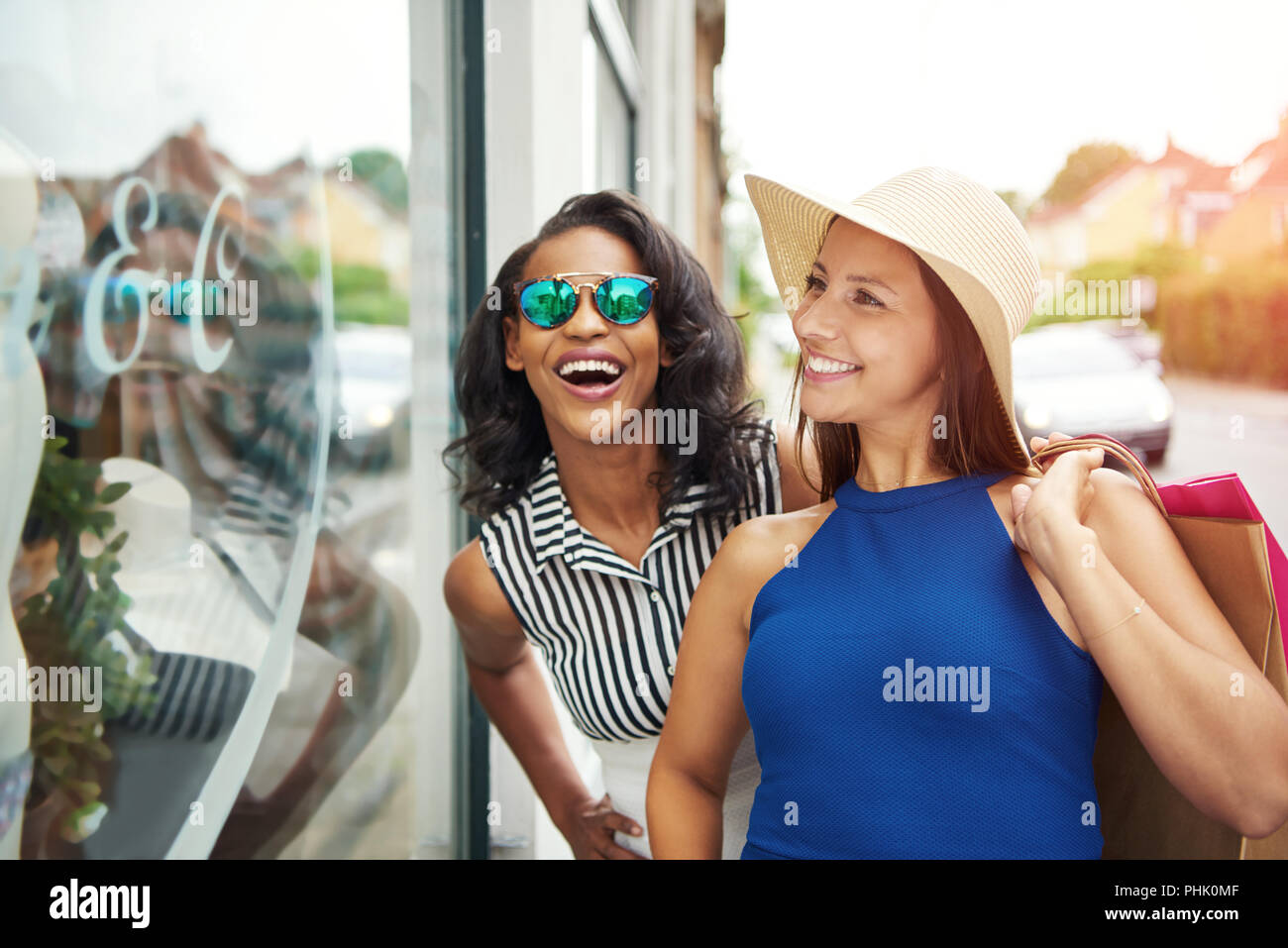 Aufgeregt und schönen begeisterte Freunde Fenster zusammen einkaufen außerhalb im Sommer Stockfoto