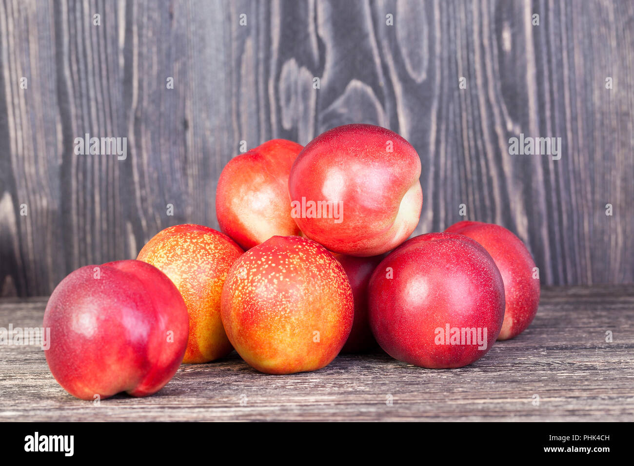 Ein Paar rote reife Hybriden von Nektarinen in der Saison ihre Reifung, liegt auf einem Brett oder Tabelle Stockfoto