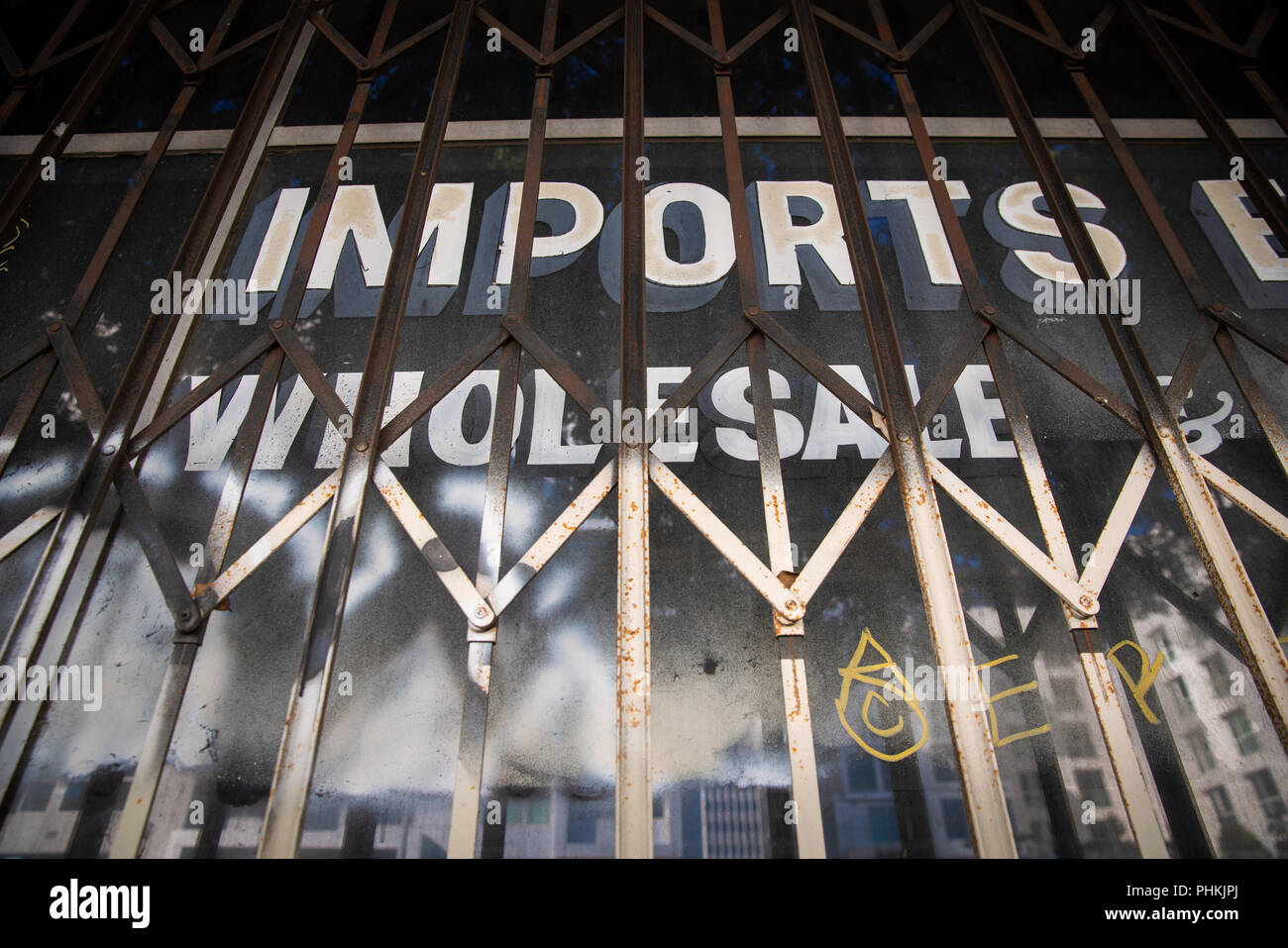 Handgemaltes Schild auf storefront Fenster, das liest, "Einfuhren Großhandel, in der Innenstadt von Los Angeles, Kalifornien. Stockfoto