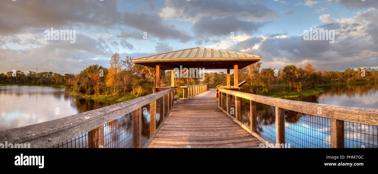 Sonnenuntergang über Pavillon auf einer hölzernen abgeschiedenen, ruhigen Promenade Stockfoto