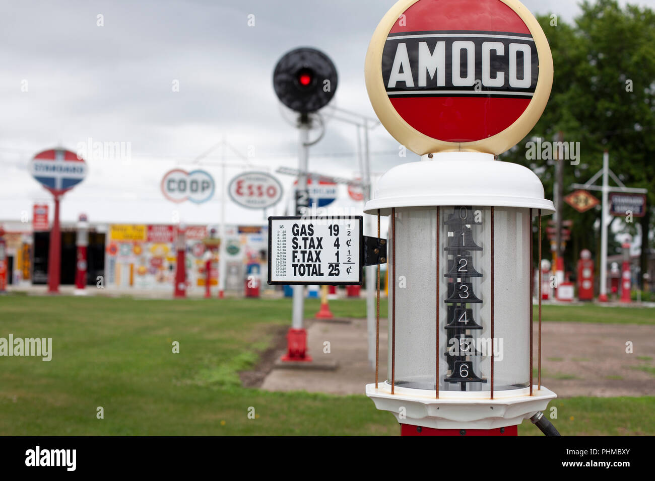 Eine alte Amoco Tankstelle steht unter einer Sammlung von Tankstelle Utensilien an einem privaten Ort in Iowa. Stockfoto