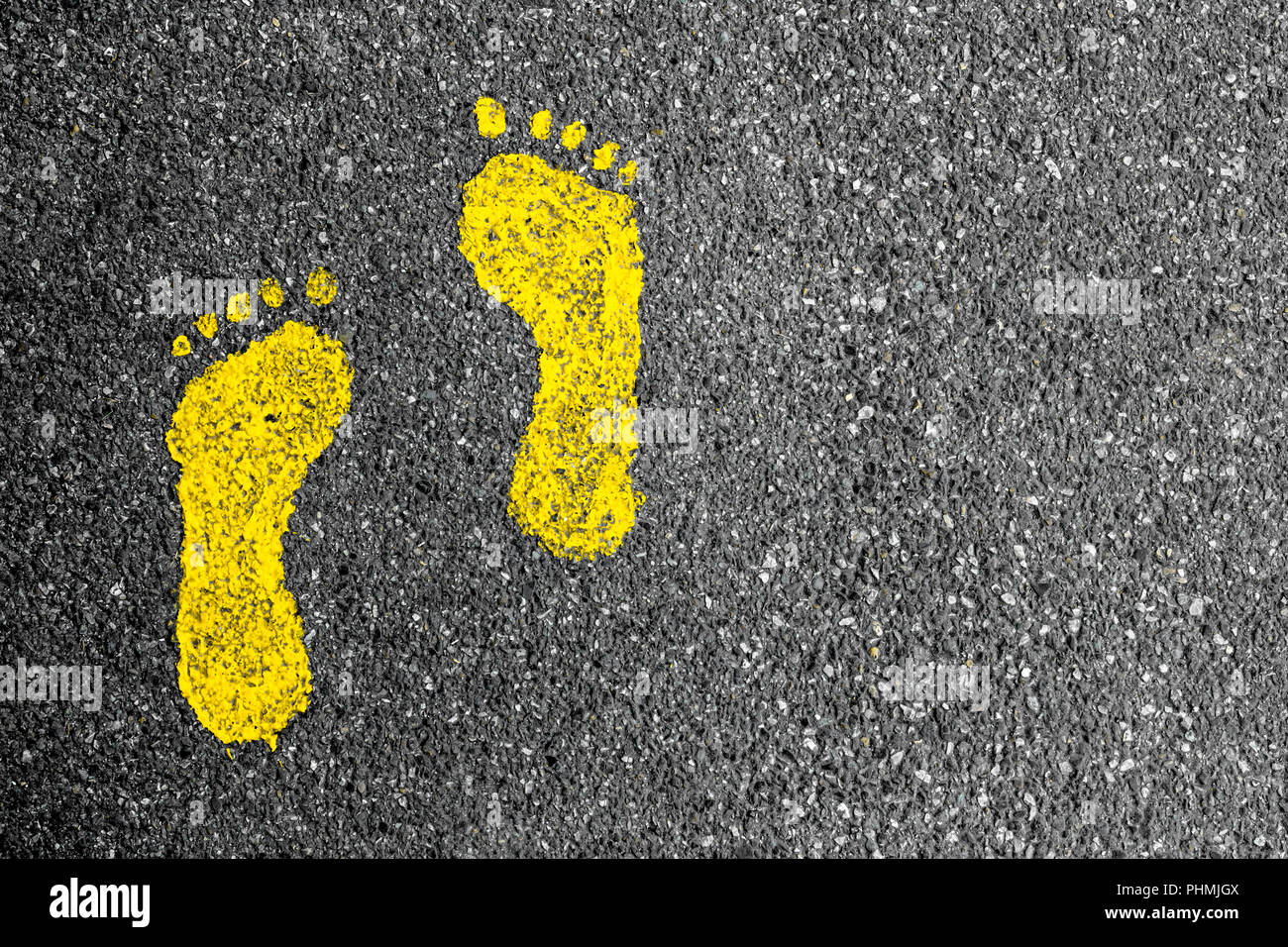 Gelbe Fußspuren auf Asphalt Stockfoto
