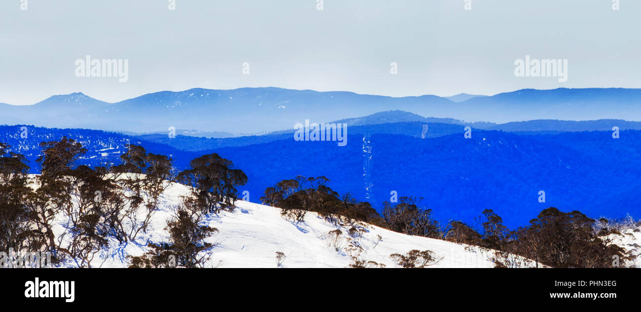 BLue Mist über Berge reicht in der Kosciuszko National Park von Australien im Winter, wenn hohe Land Hänge sind von Schnee in Perisher val abgedeckt Stockfoto