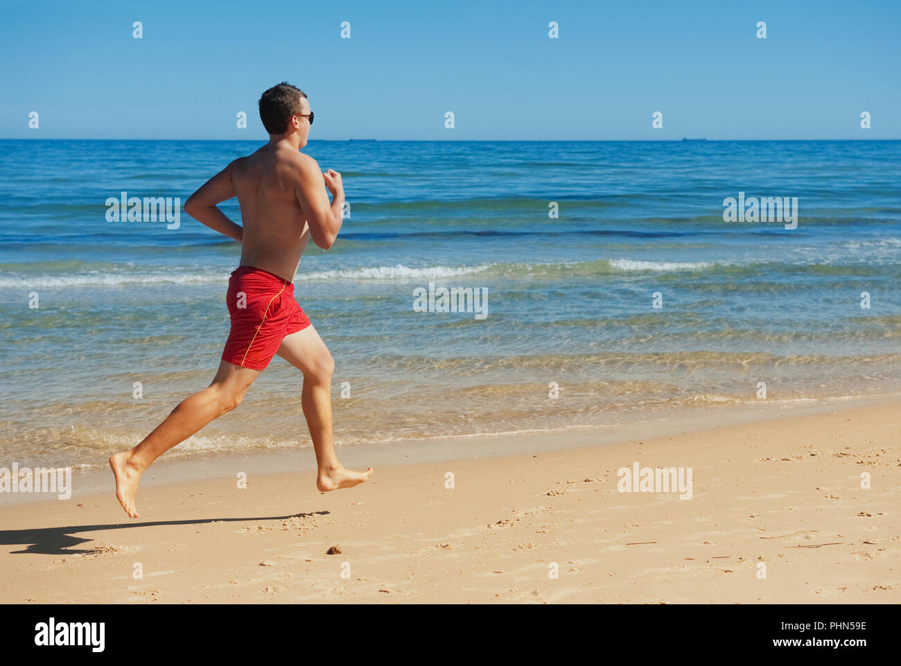 Mann läuft entlang der Küste Stockfoto