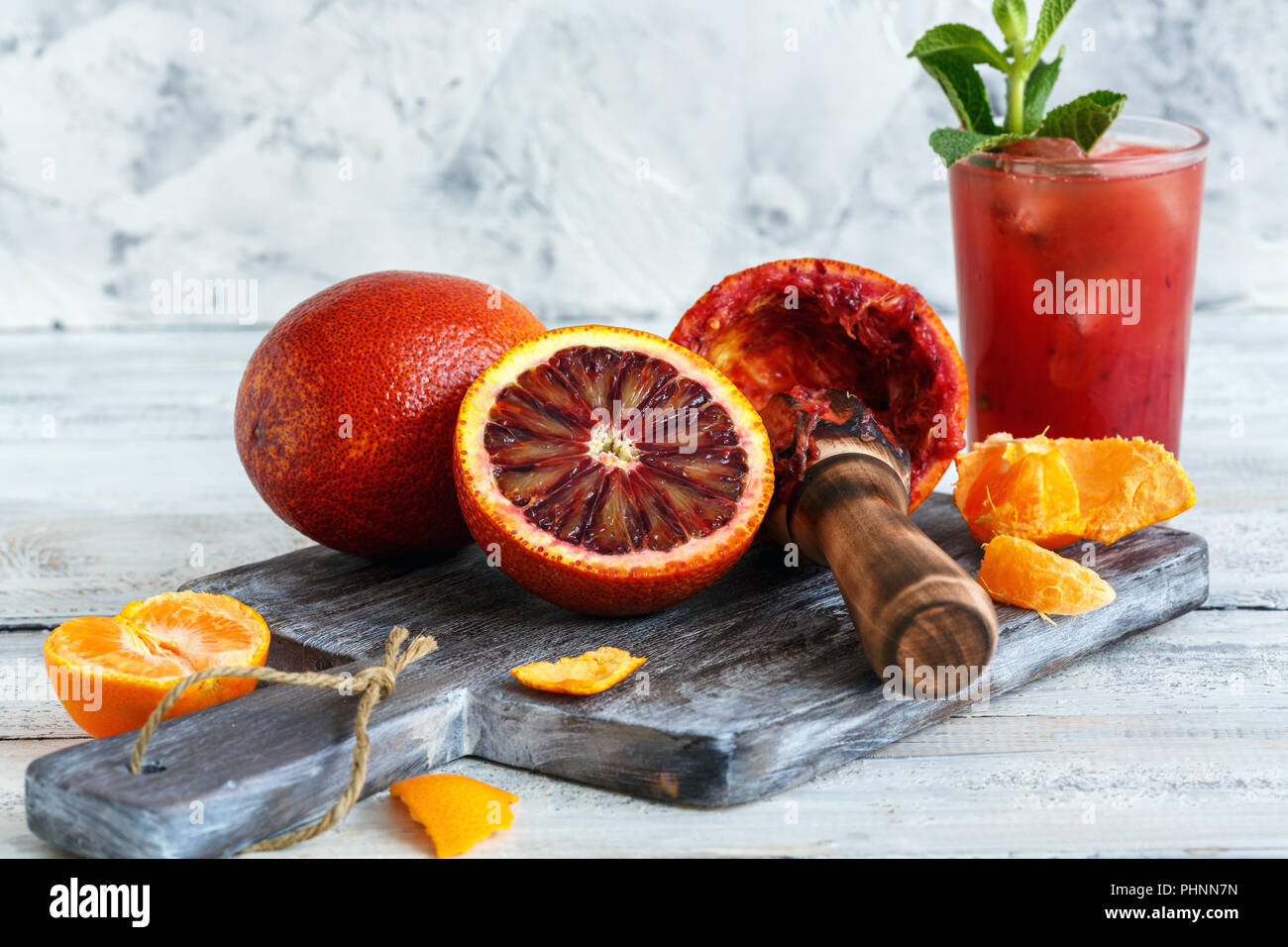 Blutorangen, Zitruspresse und ein Glas Saft. Stockfoto