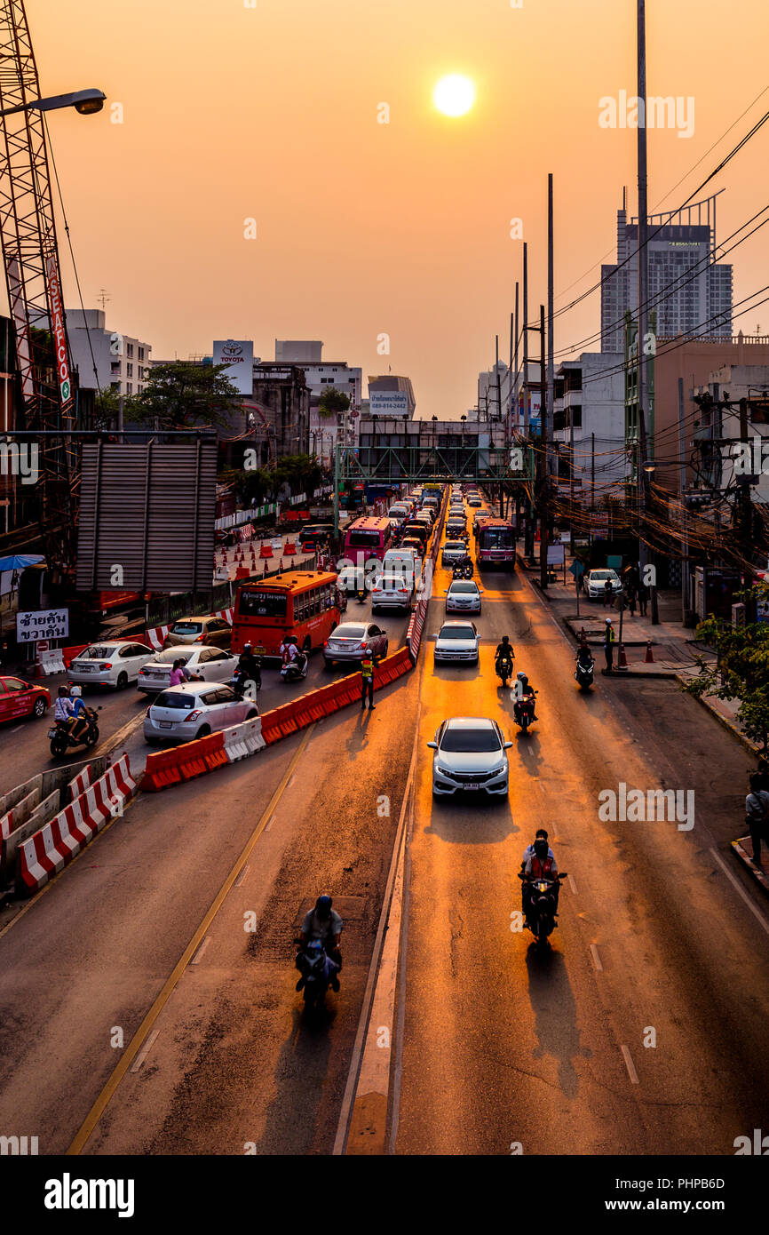 Bauunternehmen hat sich der Verkehr in Bangkok in der Nähe des Sunset mit Sun und lgiht spiegelt sich auf der Autobahn. Stockfoto