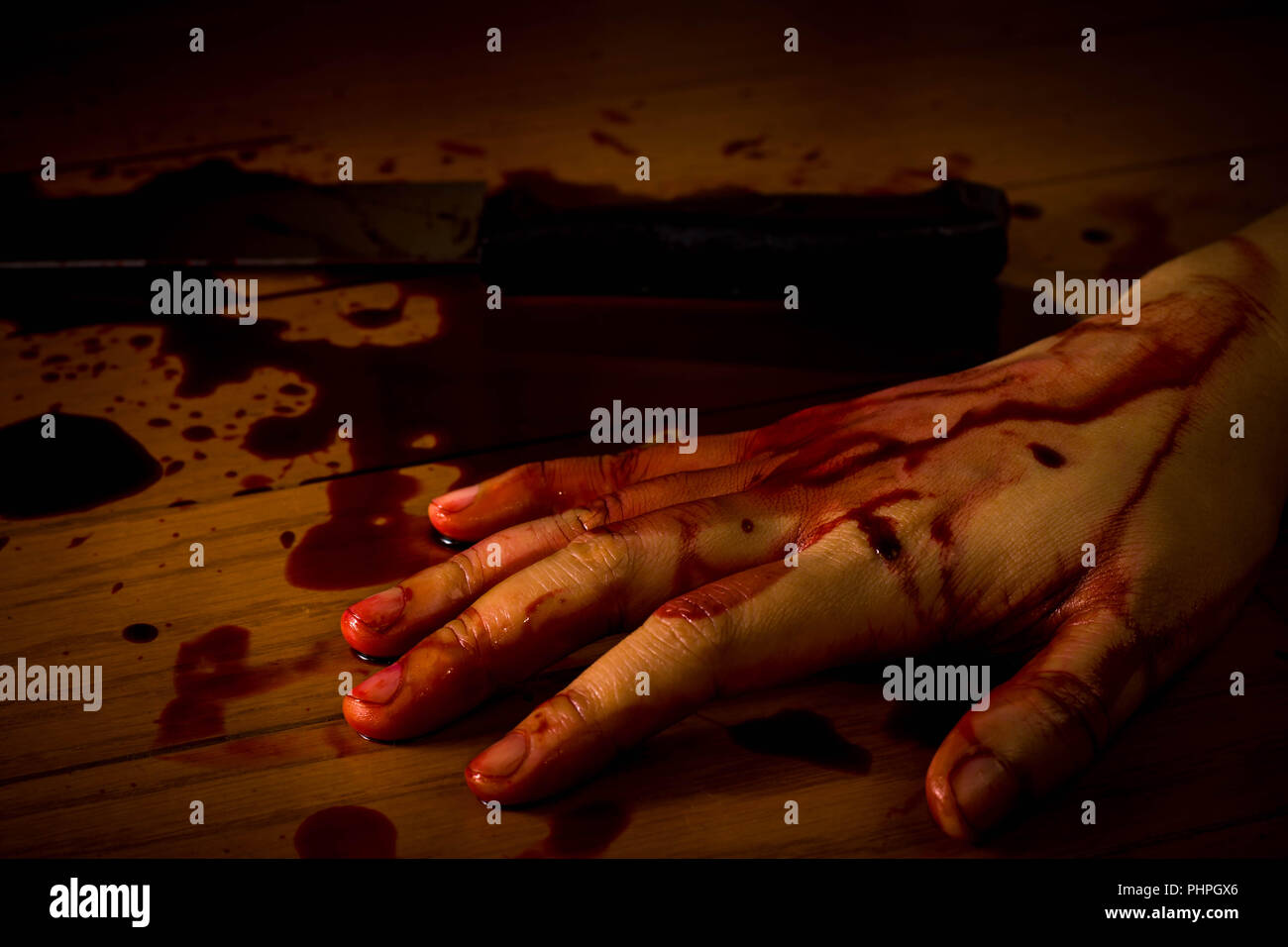 Mord, Selbstmord oder Tatort. Hand einer toten Person getränkt in Blut auf dem Boden mit dem Messer auf dem Hintergrund. Stockfoto