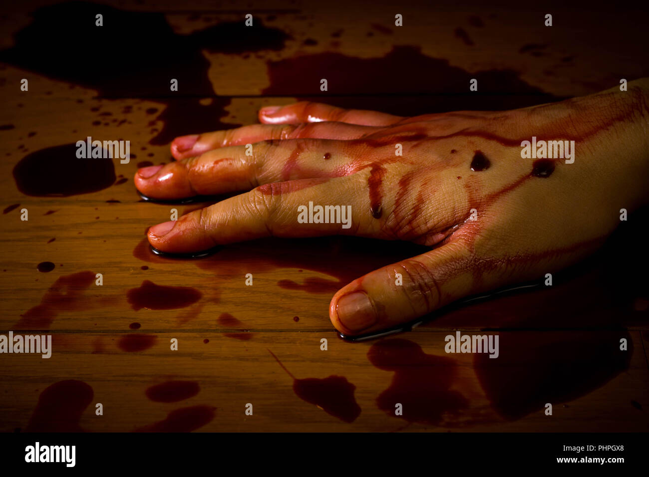 Mord, Selbstmord oder Tatort. Hand einer toten Person getränkt in Blut auf dem Boden. Stockfoto