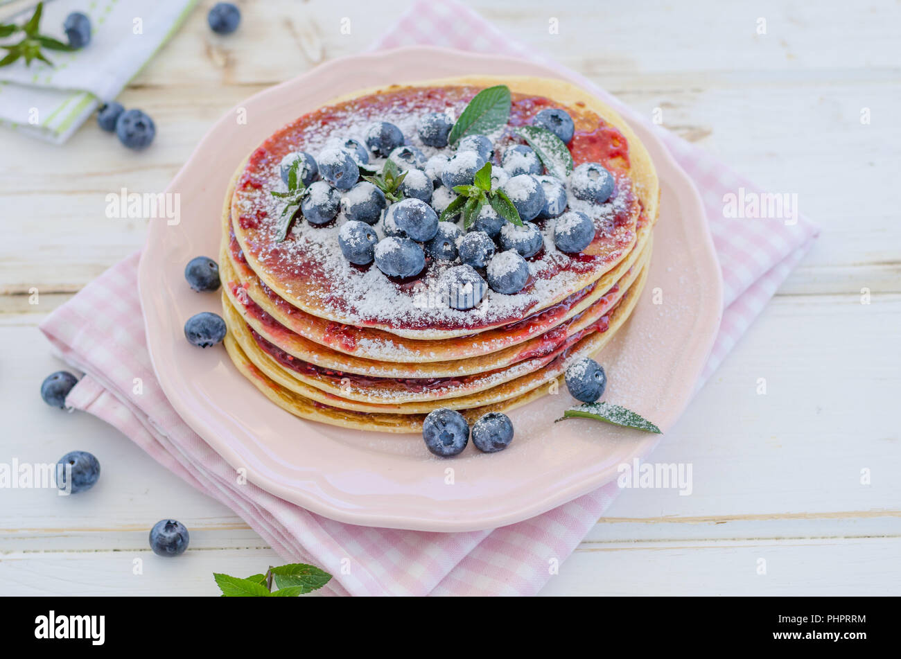 Delish Frühstück mit frischem Obst bei der Gartenparty, aussen mit Blumen hinter und frischen Kräutern auf der Oberseite Stockfoto