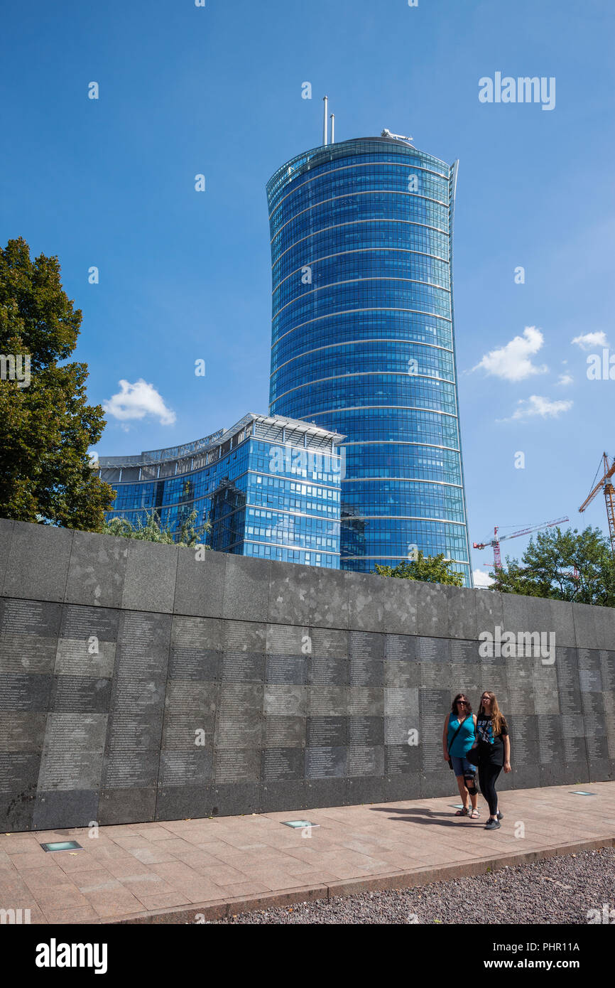 Mauer der Erinnerung mit aufständischen Namen im Museum des Warschauer Aufstandes (Polnisch: Muzeum Powstania Warszawskiego) und Warschau Turm Wolkenkratzer in Warschau, Polen Stockfoto