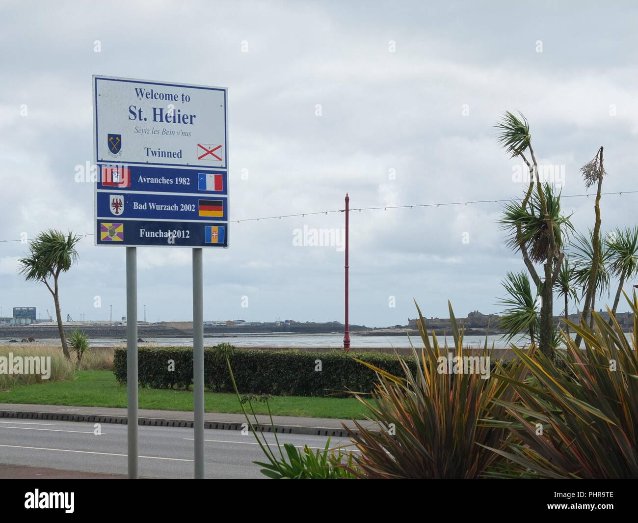 Schild für St Helier Jersey Channel Islands Feststellung twin towns mit Palmen und das Meer im Hintergrund Stockfoto
