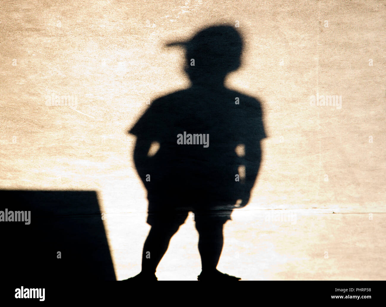 Schatten Silhouette der ein Junge mit einer Kappe, die alleine stehen Stockfoto