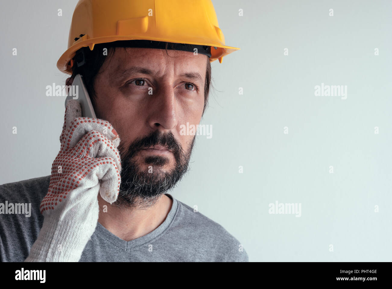 Bauingenieur Gespräch am Handy, schweren erwachsenen männlichen Person mittels Smartphone für die Kommunikation mit den Arbeitern auf der Baustelle Stockfoto