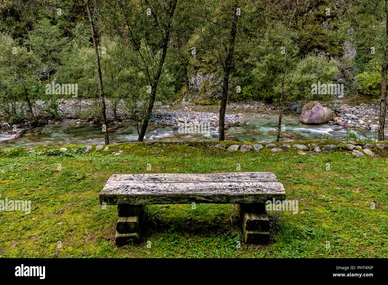 Bahnschwellen für Stadtmöblierung in der Wiese am Rand von einem Bergbach im Herbst Stockfoto