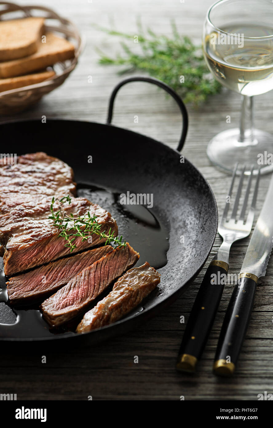Gegrillte Rindersteaks mit Gewürzen auf hölzernen Tisch Stockfoto