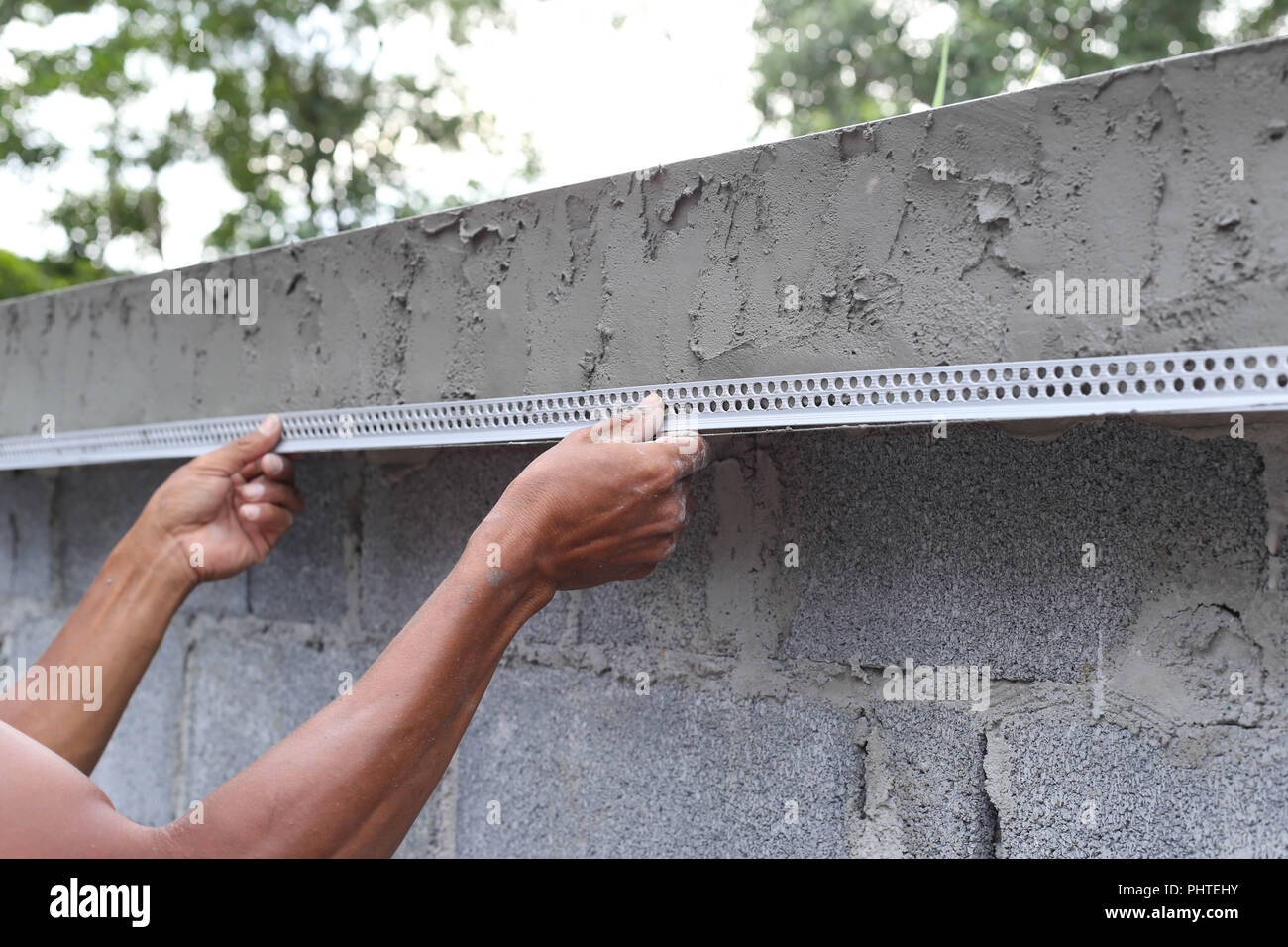 Asiatischer Mann mit einem nassen Beton Wand Stockfoto