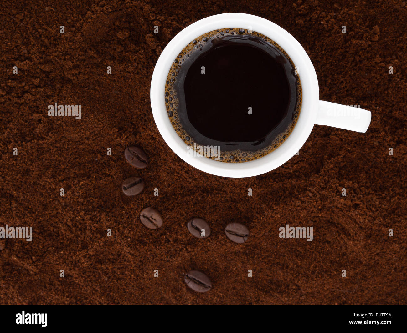 Stark, schwarz italienischen Espresso in einem weißen Schale, mit frisch gemahlenem Kaffee und Bohnen. Stockfoto