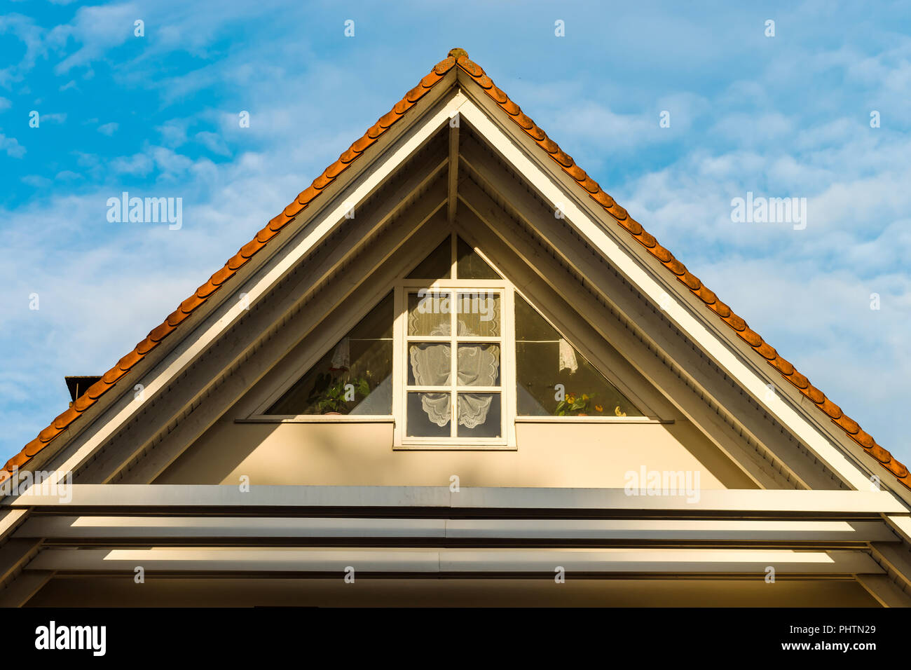 Schönes Dorfhaus mit Dreieck Dach und Blumen Dekorationen auf dem Balkon Stockfoto