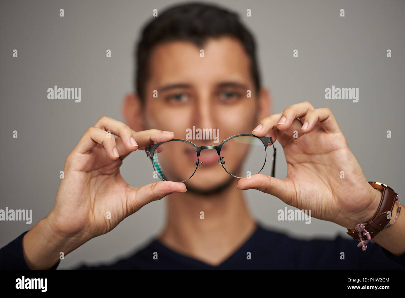Mann mit Brille in den Händen auf unscharfen Hintergrund Stockfoto