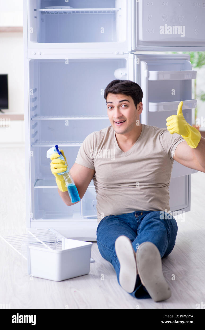 Mann Reinigung Kühlschrank im hygienekonzept Stockfoto