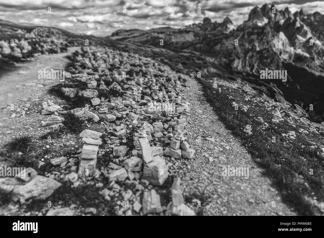 Schwarzweiß-Effekt von Cairns in der Nähe von einem Pfad am Fuße der Drei Zinnen, mit Cadini di Misurina Hintergrund, Dolomiten, Italien Stockfoto