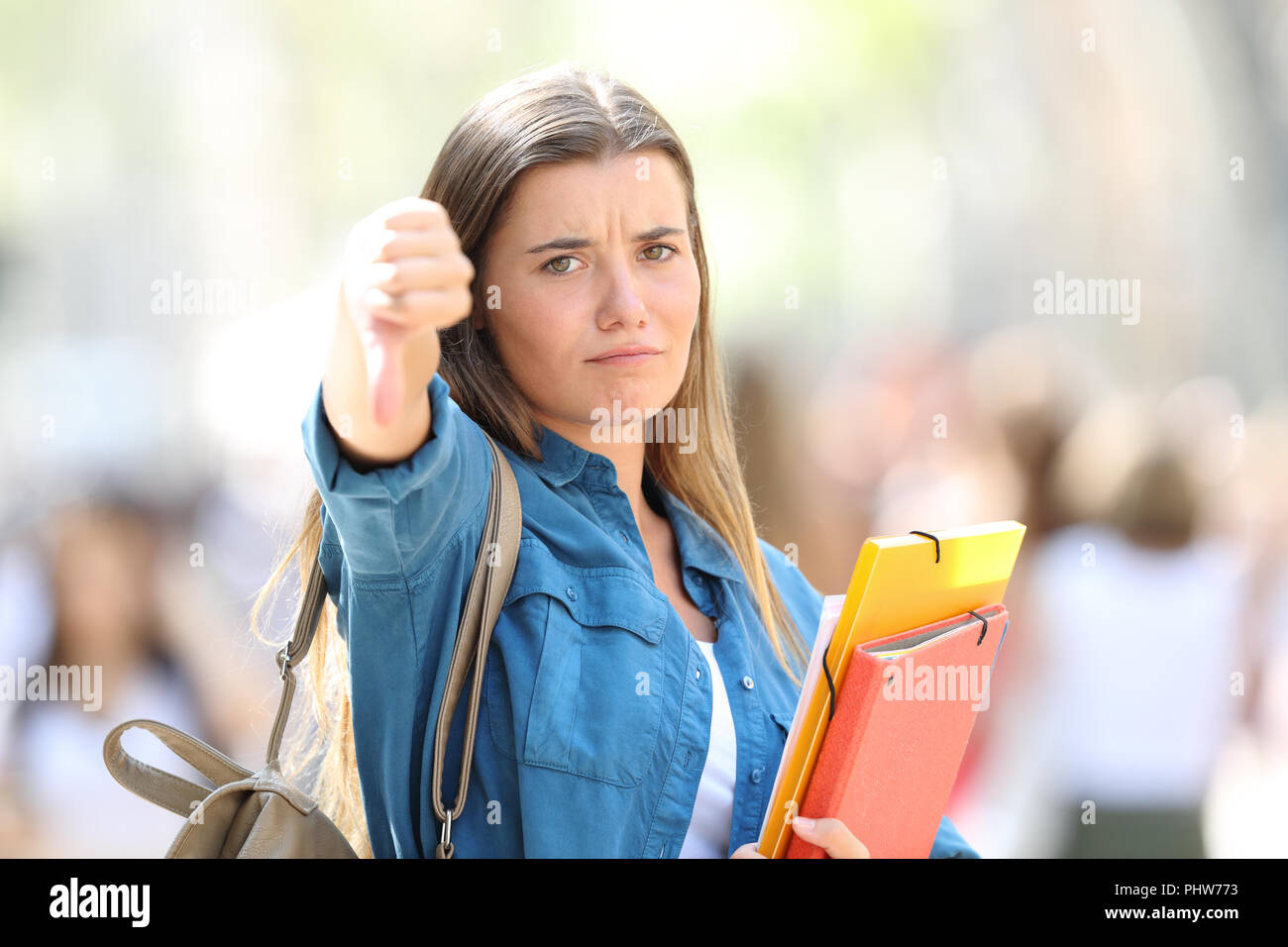 Angry student Gestik Daumen unten an der Kamera, die in der Straße Stockfoto