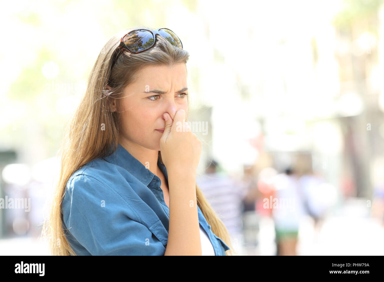 Mädchen, die ihre Nase wegen schlechten Geruch in der Straße Stockfoto