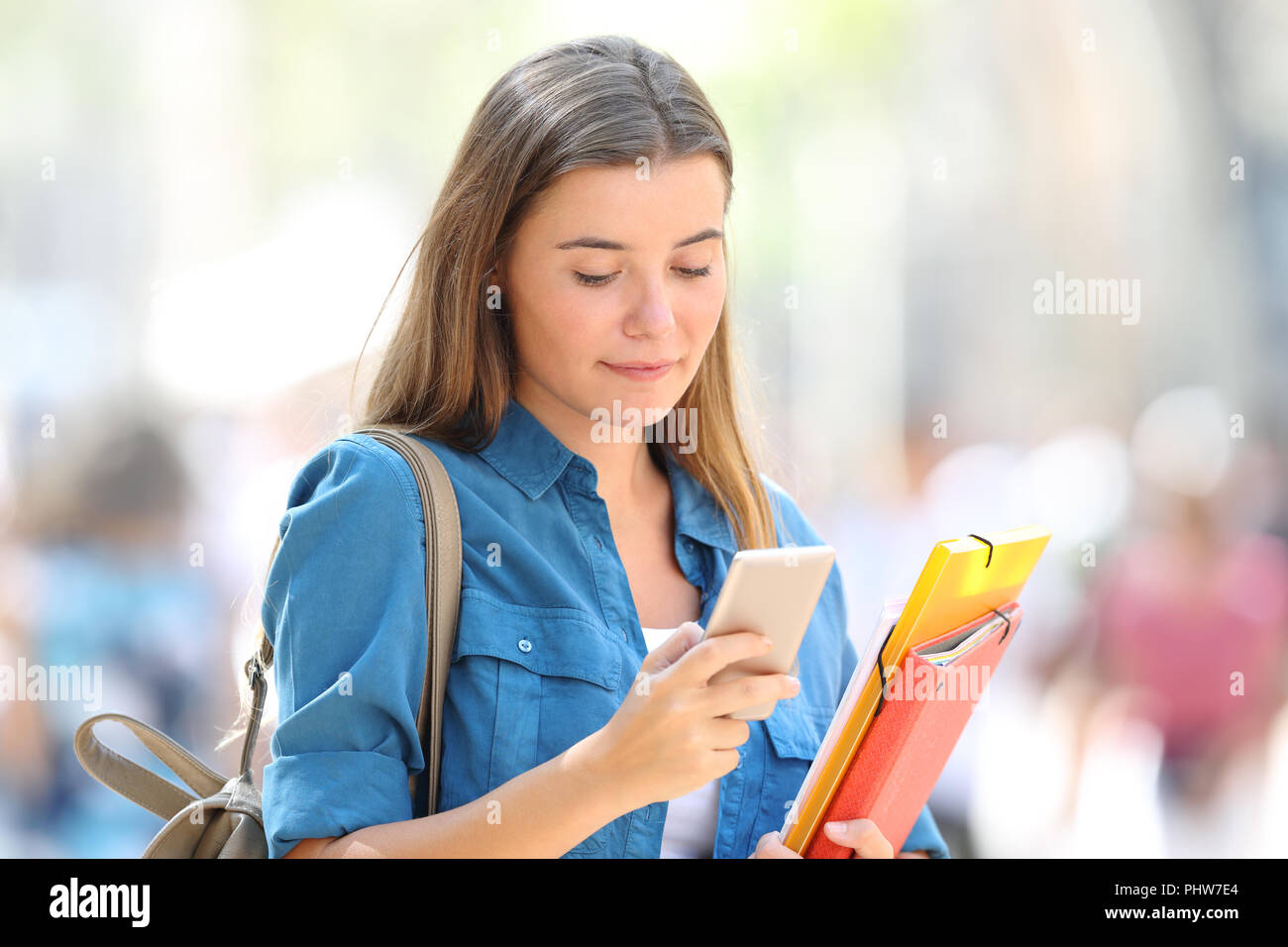 Entspannt Student mit einem Smart Phone zu Fuß auf der Straße Stockfoto