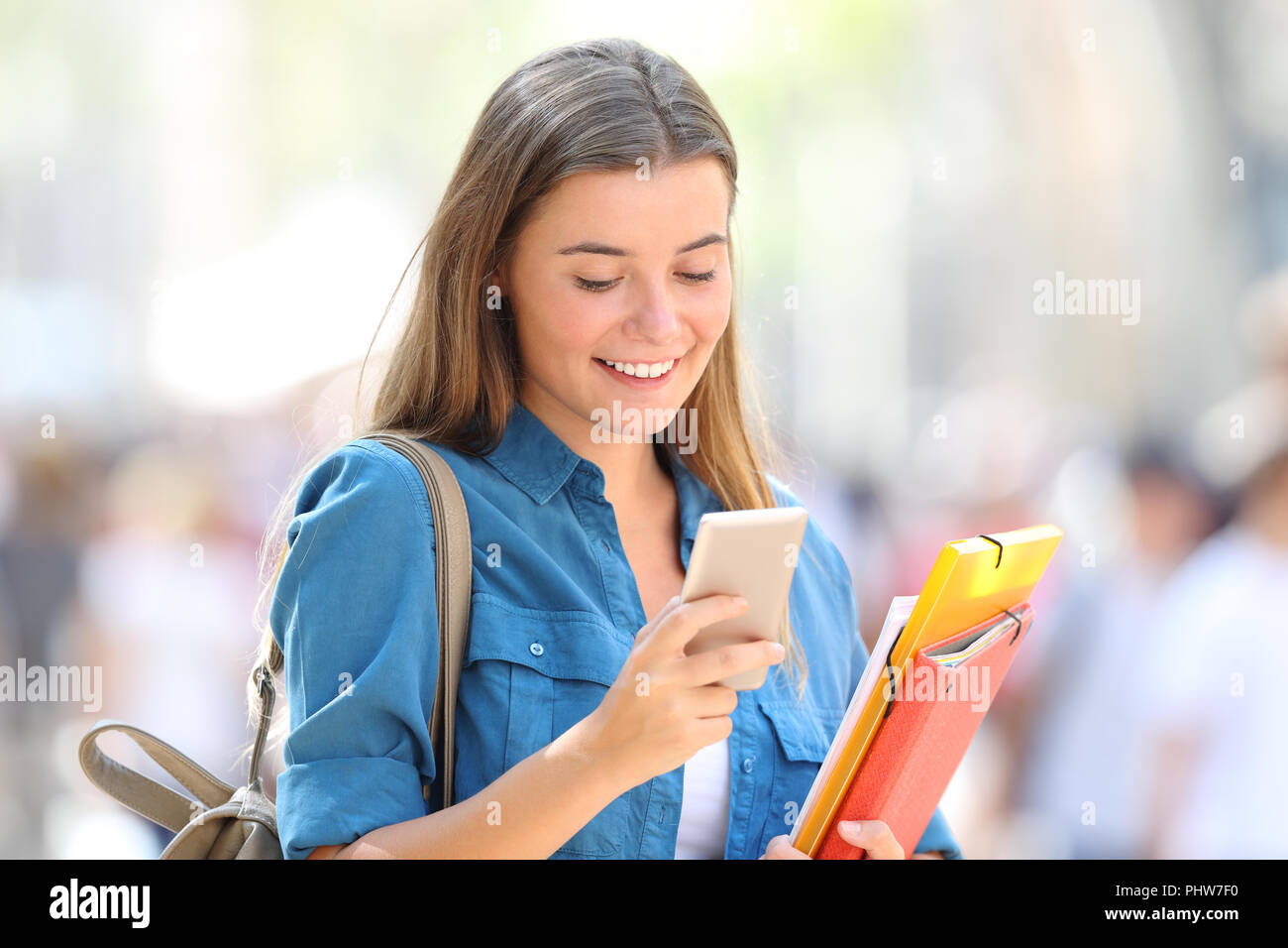 Gerne student verwendet ein Smart Phone zu Fuß auf der Straße Stockfoto