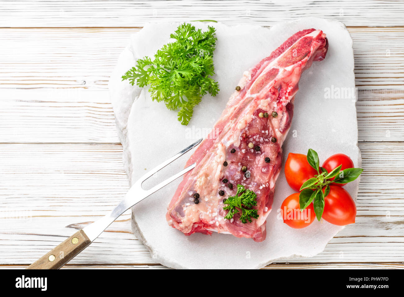 Stück Fleisch Schweinefleisch Brustbein rippen Spachtel mit Salz und Pfeffer gewürzt und Zweig Basilikum Stockfoto