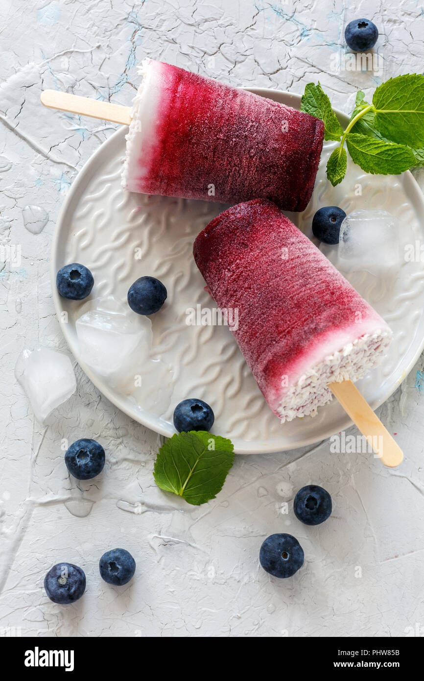 Hausgemachte Kokosnuss Eis am Stiel mit frischen Beeren. Stockfoto