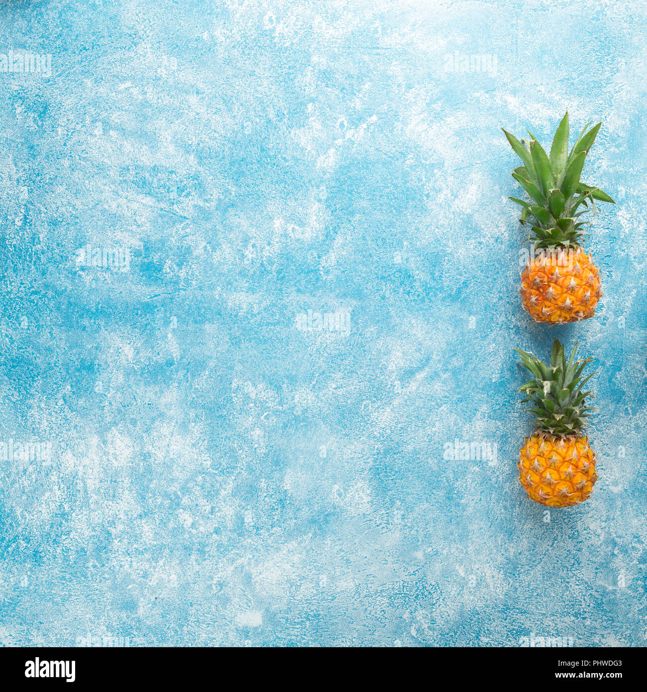 Zwei mini Ananas auf einem blauen Hintergrund Stockfoto