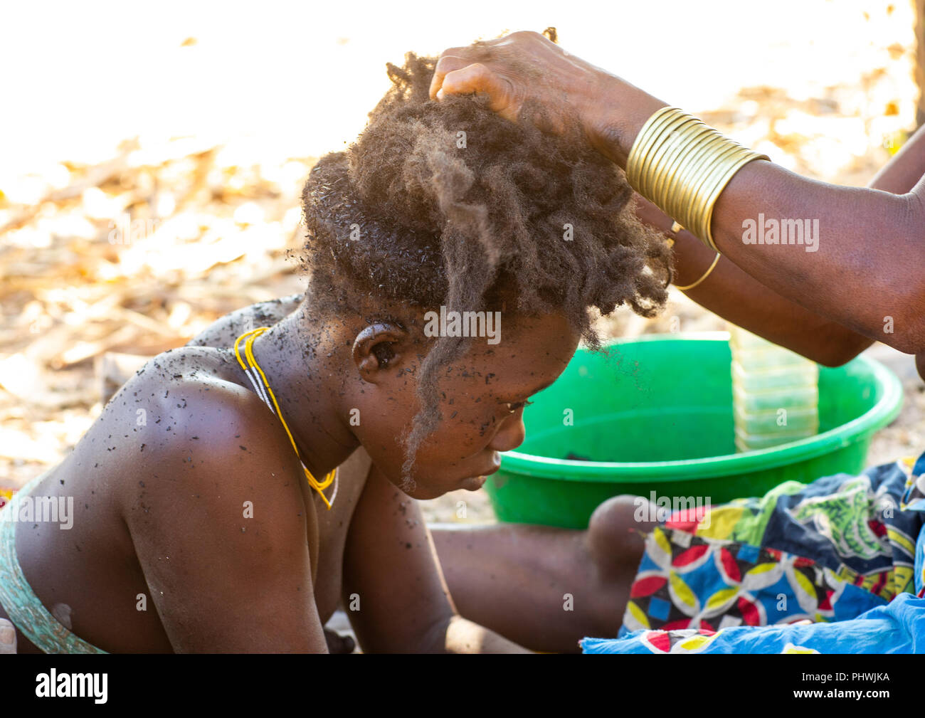 Nguendelengo Stamm Frau computing Öl im Haar traditionelle Brötchen zu machen, Provinz Namibe, Capangombe, Angola Stockfoto