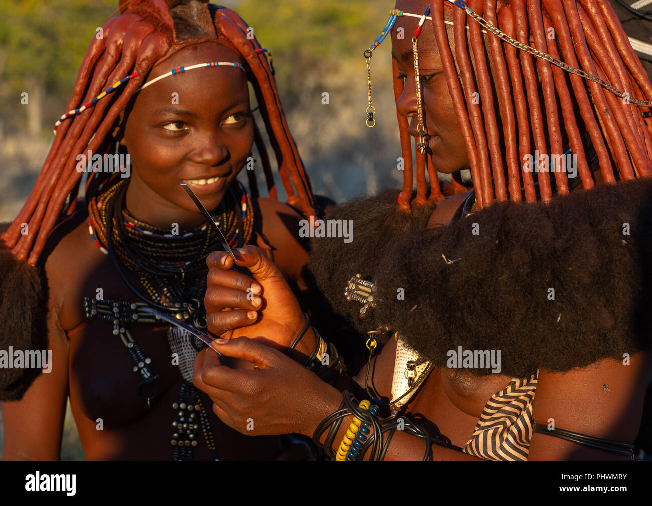 Himba Frauen auf Polaroids, Cunene Provinz, Oncocua, Angola Stockfoto
