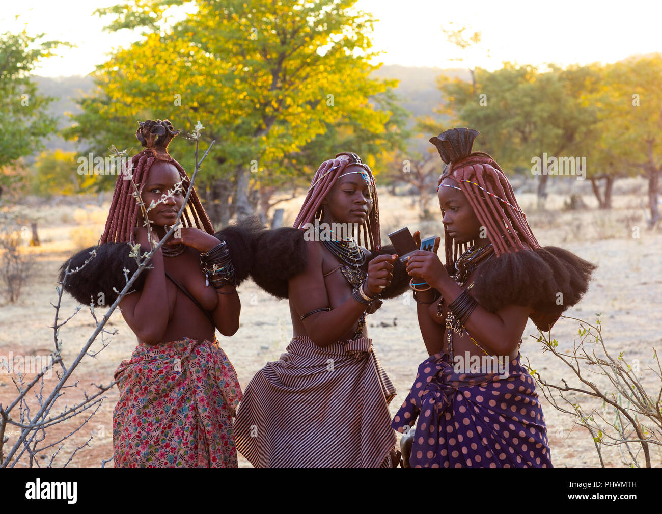 Himba Frauen auf Polaroids, Cunene Provinz, Oncocua, Angola Stockfoto