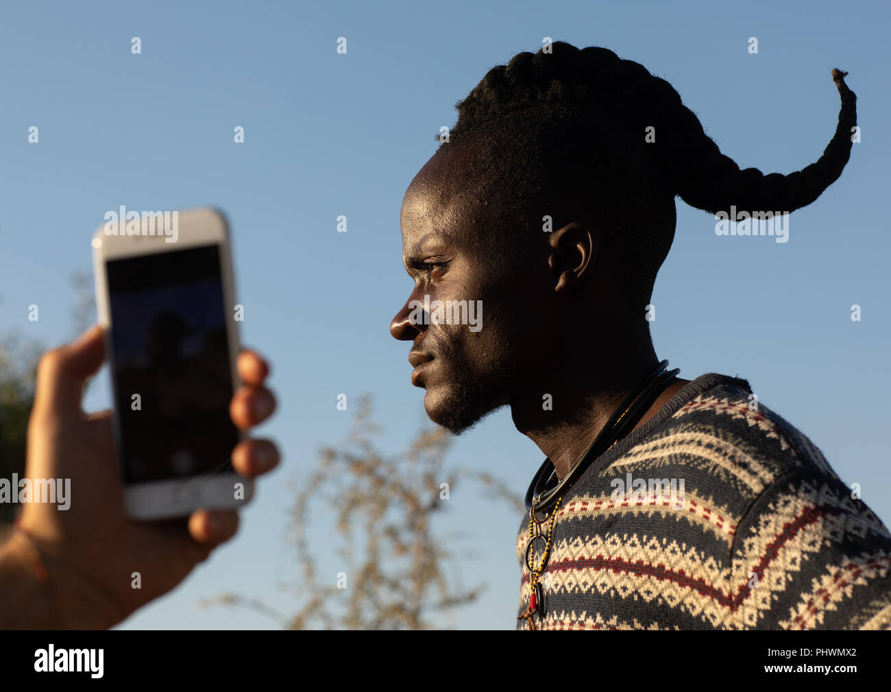 Tourist, ein Bild mit einem Handy von einem Himba einzelner Mann, Cunene Provinz, Oncocua, Angola Stockfoto